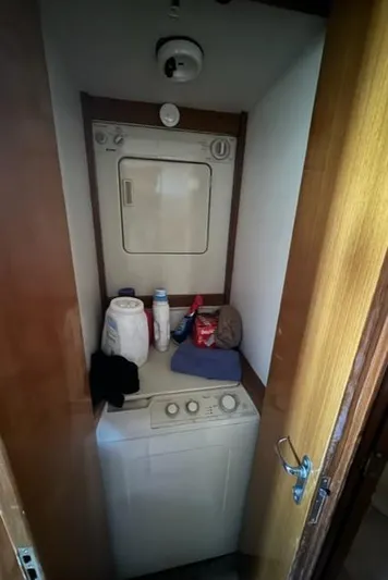  Yacht Photos Pics Laundry area with stacked washer and dryer inside a 1998 Viking 43 Convertible boat.