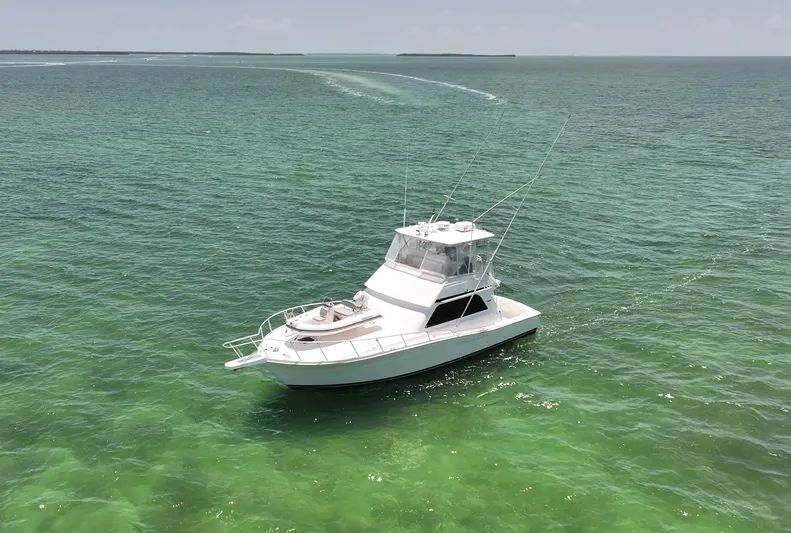  Yacht Photos Pics Viking 43 Convertible 1998 yacht cruising on clear green ocean waters.