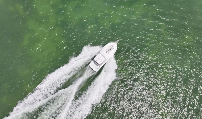  Yacht Photos Pics Aerial view of 1998 Viking 43 Convertible yacht cruising on green ocean waters.