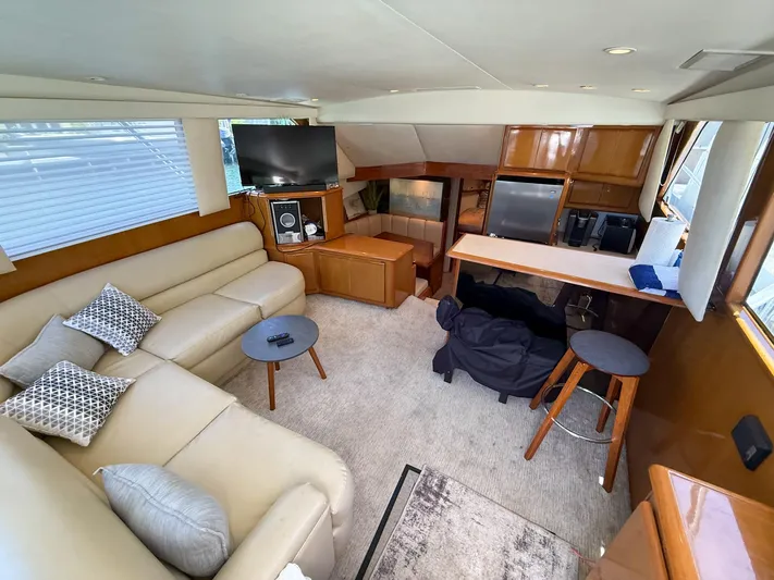  Yacht Photos Pics Interior of 1998 Viking 43 Convertible yacht with beige seating, TV, and kitchenette.