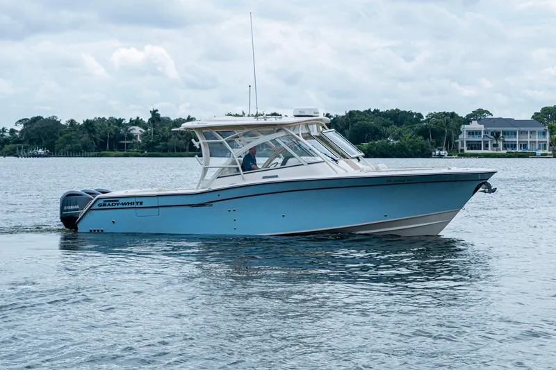  Yacht Photos Pics 2017 Grady-White Freedom 335 boat cruising on a calm lake with scenic background.
