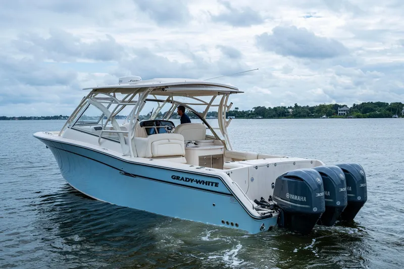  Yacht Photos Pics 2017 Grady-White Freedom 335 boat with triple Yamaha engines on a calm lake.