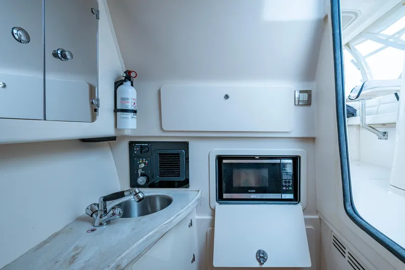  Yacht Photos Pics 2017 Grady-White Freedom 335 boat interior with kitchenette, sink, and microwave.