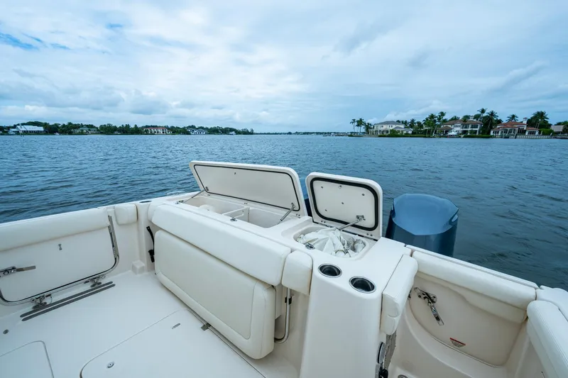  Yacht Photos Pics 2017 Grady-White Freedom 335 boat on calm water, open storage compartments.