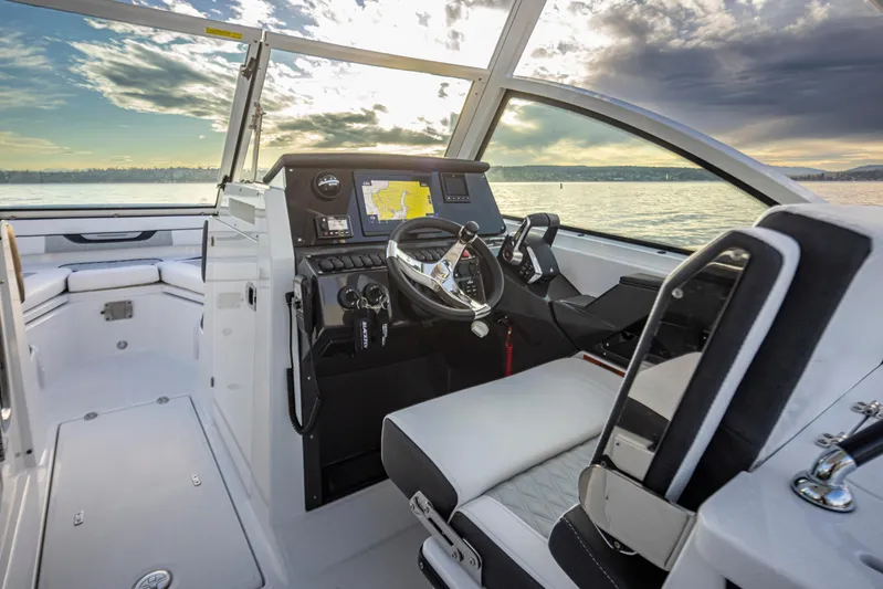  Yacht Photos Pics 2024 Blackfin 252 DC boat interior with modern dashboard and steering, overlooking serene waters.
