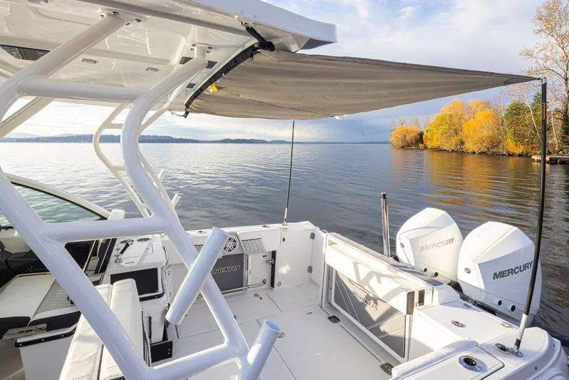  Yacht Photos Pics 2024 Blackfin 252 DC boat on serene lake with autumn trees and dual Mercury engines.
