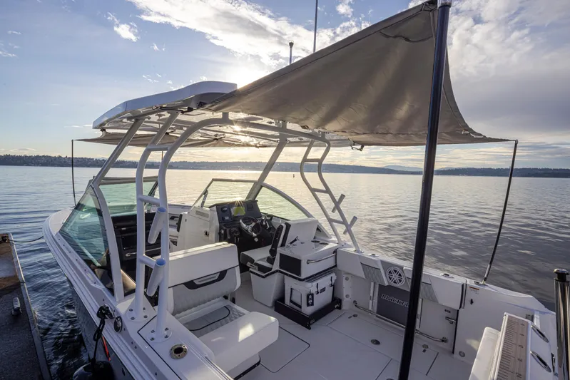  Yacht Photos Pics 2024 Blackfin 252 DC boat with canopy on calm water at sunset.