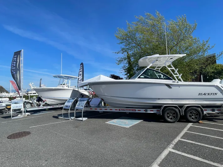 Yacht Photos Pics 2024 Blackfin 252 DC boat displayed on a trailer in a parking lot.
