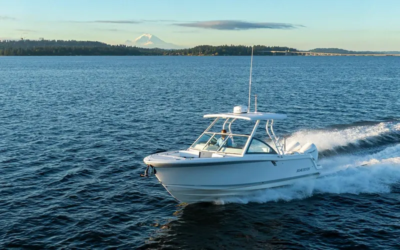  Yacht Photos Pics 2024 Blackfin 252 DC cruising on a serene lake with distant mountains.