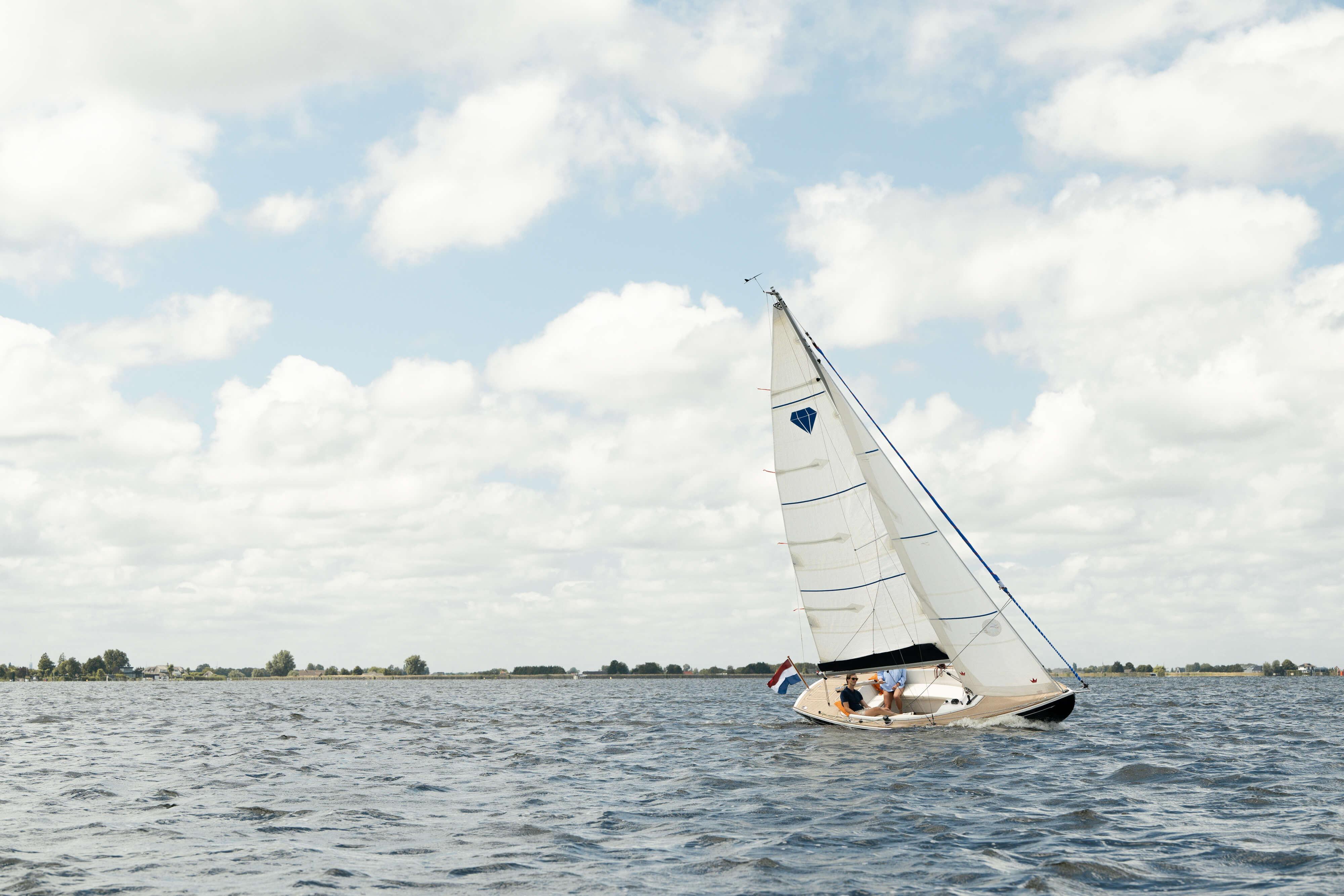 Saffier SC 6.5 Cruise 2026 sailing on a calm lake under a cloudy sky.