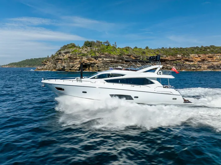 Just For Fun Yacht Photos Pics Sunseeker Manhattan 73 yacht cruising on blue waters near rocky coastline, 2011 model.