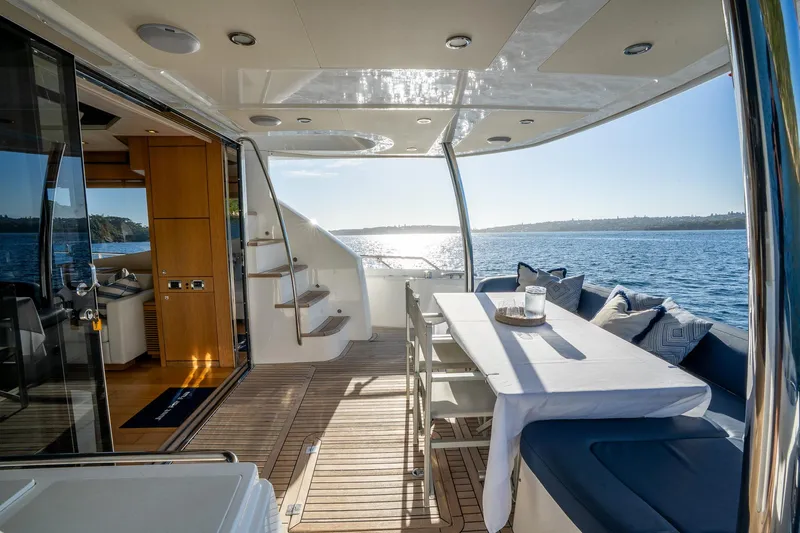 Just For Fun Yacht Photos Pics Luxurious Sunseeker Manhattan 73 yacht deck with dining area, ocean view, and elegant interior, 2011 model.