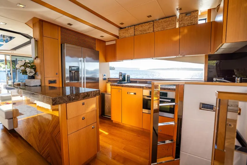 Just For Fun Yacht Photos Pics Luxurious kitchen interior of 2011 Sunseeker Manhattan 73 yacht with modern appliances and wood finish.