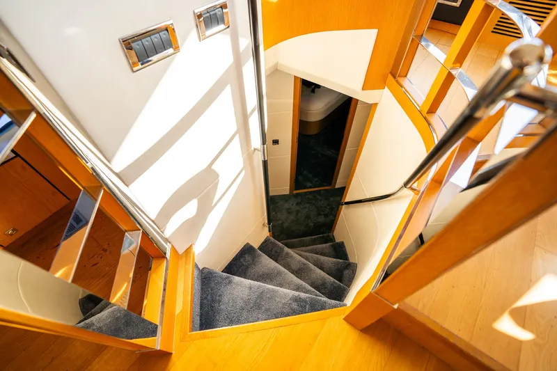 Just For Fun Yacht Photos Pics Staircase inside 2011 Sunseeker Manhattan 73 yacht, featuring elegant wood and carpet design.