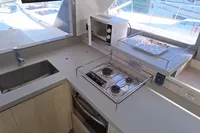Modern kitchen in 2019 Leopard 45 yacht with stove, sink, and microwave.