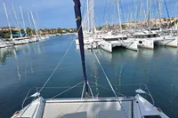 Leopard 45 catamaran in marina, surrounded by sailboats, calm water, sunny day, 2019 model.