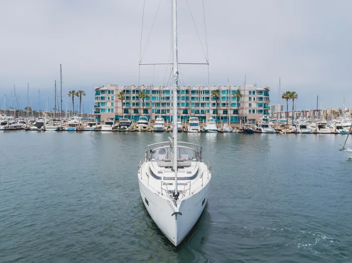 Kalesma Yacht Photos Pics 2021 Bavaria C50 Style yacht docked in a marina with modern buildings in the background.