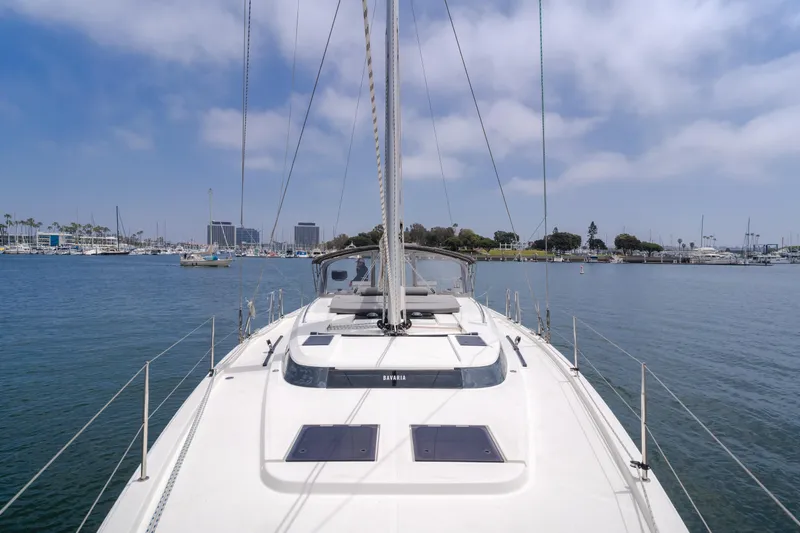 Kalesma Yacht Photos Pics 2021 Bavaria C50 Style yacht sailing in a calm marina under a partly cloudy sky.