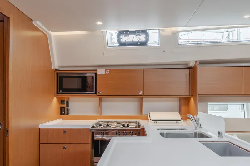 Kalesma Yacht Photos Pics Modern kitchen interior of 2021 Bavaria C50 Style yacht with wood cabinetry and appliances.