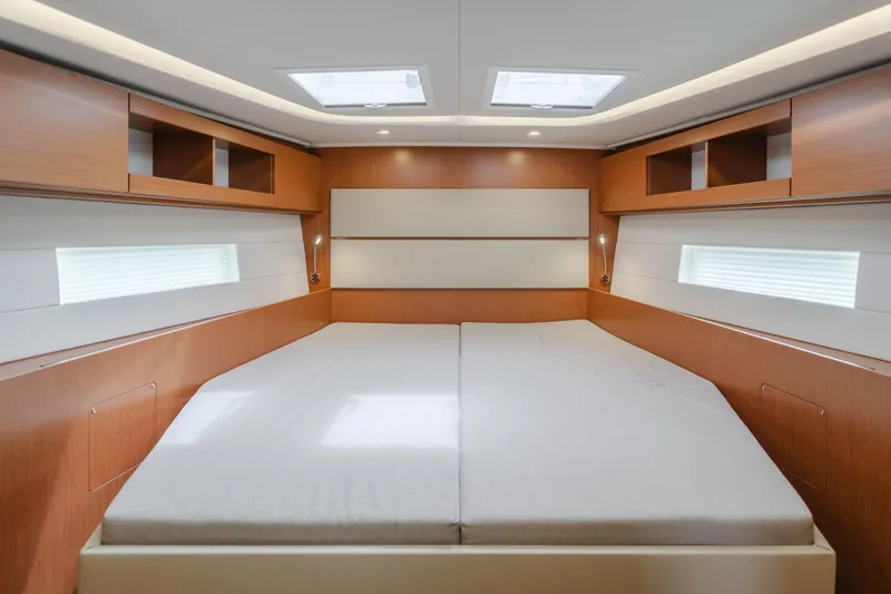 Kalesma Yacht Photos Pics Luxurious interior of 2021 Bavaria C50 Style yacht with spacious bed and wooden cabinetry.