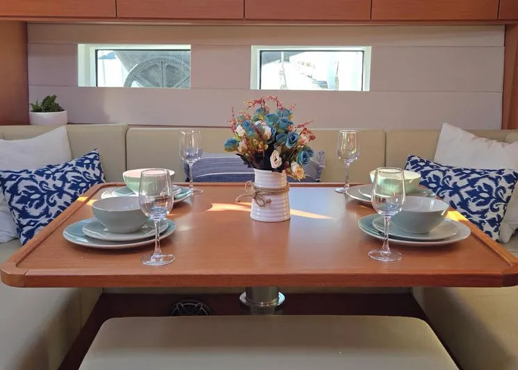 Kalesma Yacht Photos Pics Elegant dining setup in 2021 Bavaria C50 Style yacht interior with floral centerpiece.