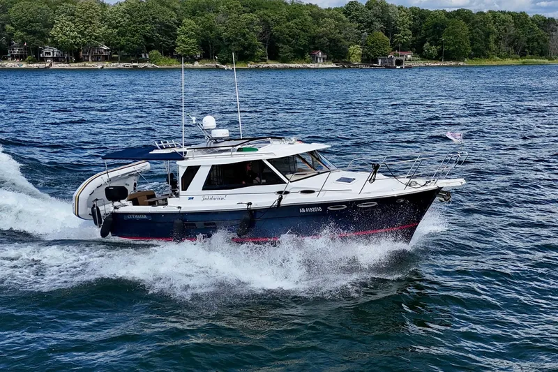  Yacht Photos Pics 2014 Cutwater C30 Sedan NW cruising on a scenic lake with lush green shoreline.