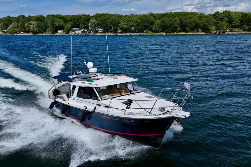  Yacht Photos Pics 2014 Cutwater C30 Sedan NW cruising on a scenic lake with lush shoreline.
