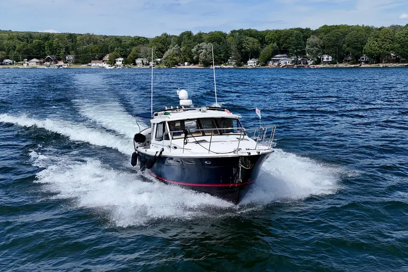  Yacht Photos Pics 2014 Cutwater C30 Sedan NW cruising on a scenic lake with forested shoreline.