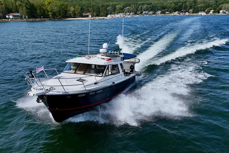  Yacht Photos Pics 2014 Cutwater C30 Sedan NW cruising on a scenic lake with lush shoreline.