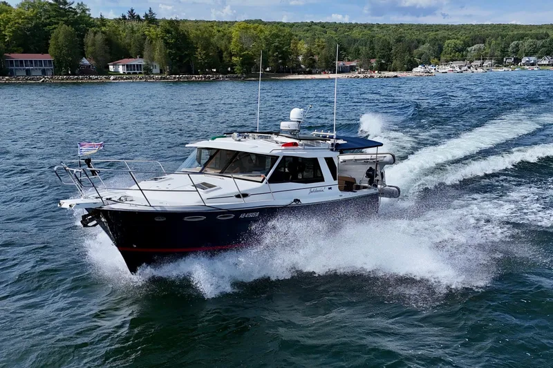  Yacht Photos Pics 2014 Cutwater C30 Sedan NW cruising on a scenic lake with forested shoreline.