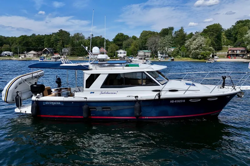  Yacht Photos Pics 2014 Cutwater C30 Sedan NW boat on a lake with scenic shoreline background.