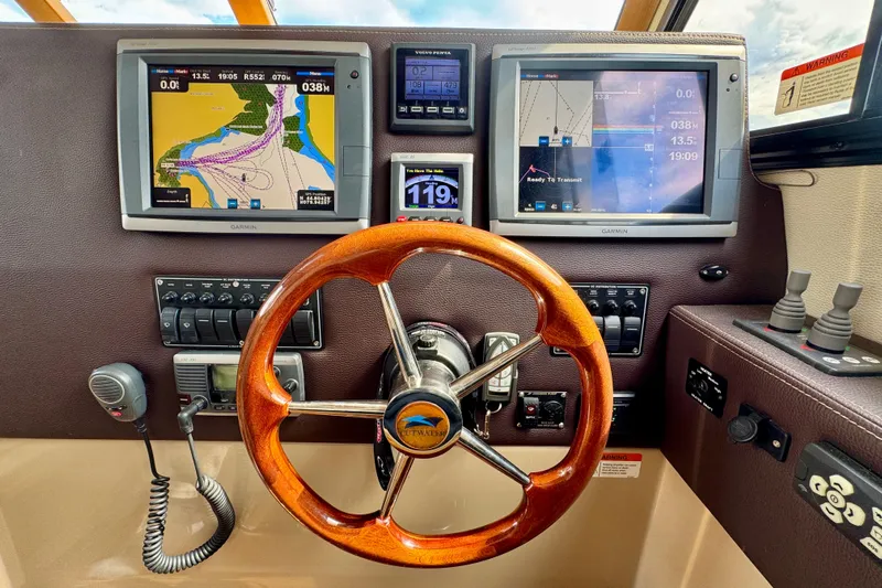  Yacht Photos Pics Helm of 2014 Cutwater C30 Sedan NW with navigation screens and wooden steering wheel.