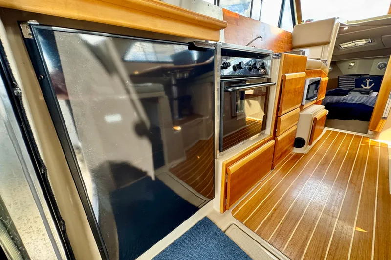  Yacht Photos Pics 2014 Cutwater C30 Sedan NW interior with wood flooring, kitchen appliances, and cozy seating area.