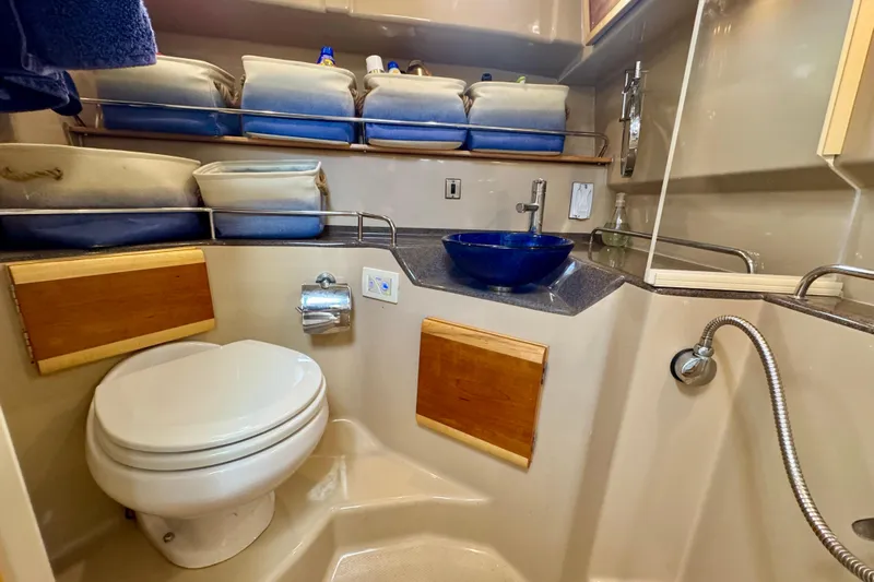  Yacht Photos Pics Compact bathroom in 2014 Cutwater C30 Sedan NW with toilet, blue sink, and storage shelves.