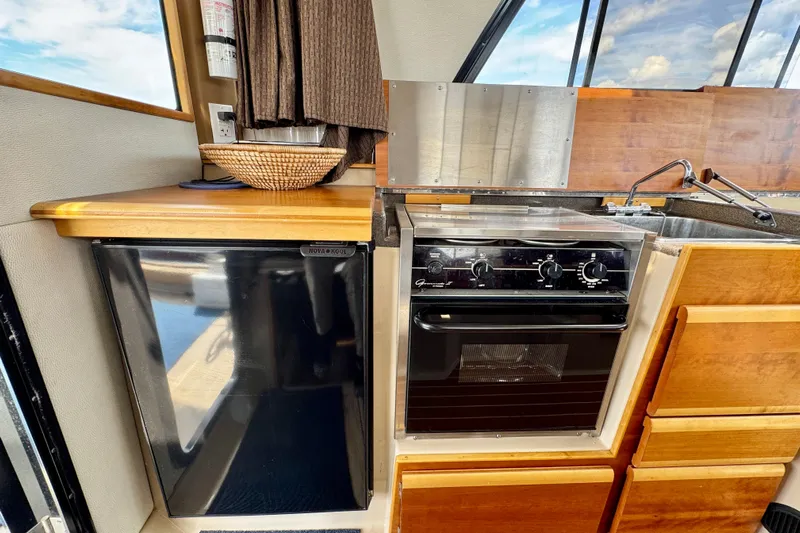  Yacht Photos Pics 2014 Cutwater C30 Sedan NW kitchen with fridge, stove, and wooden cabinetry.
