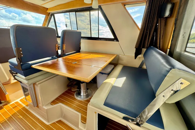  Yacht Photos Pics Interior of 2014 Cutwater C30 Sedan NW with wooden table and blue seating.