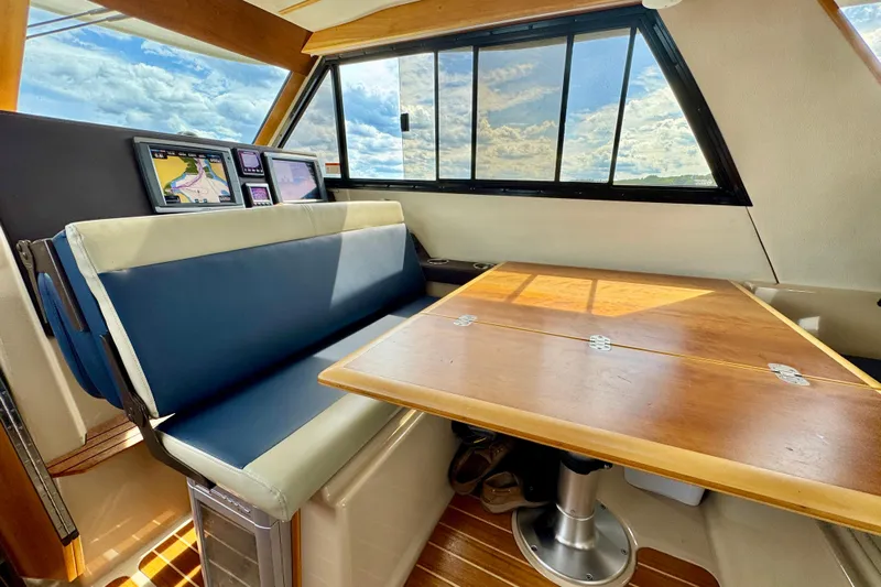  Yacht Photos Pics Interior of 2014 Cutwater C30 Sedan NW with navigation screens and wooden table.