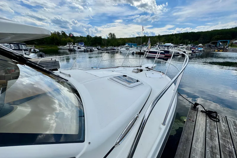  Yacht Photos Pics 2014 Cutwater C30 Sedan NW docked at a scenic marina under a partly cloudy sky.
