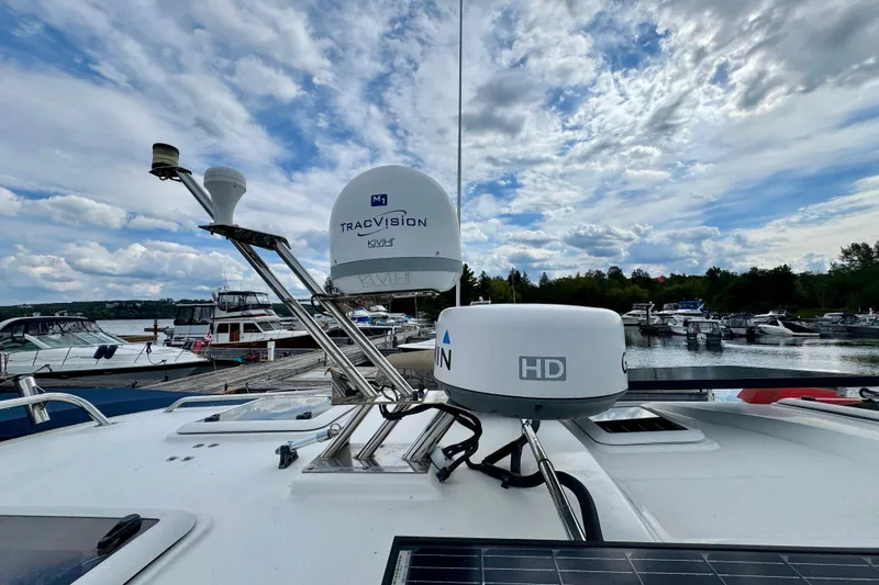  Yacht Photos Pics 2014 Cutwater C30 Sedan NW with satellite equipment, docked at a marina under a cloudy sky.