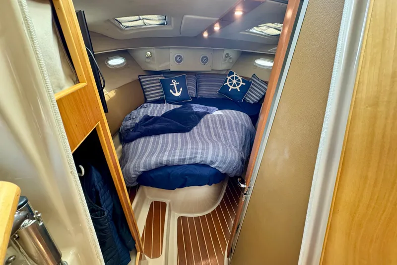  Yacht Photos Pics Cozy cabin interior of 2014 Cutwater C30 Sedan NW with nautical-themed bedding.