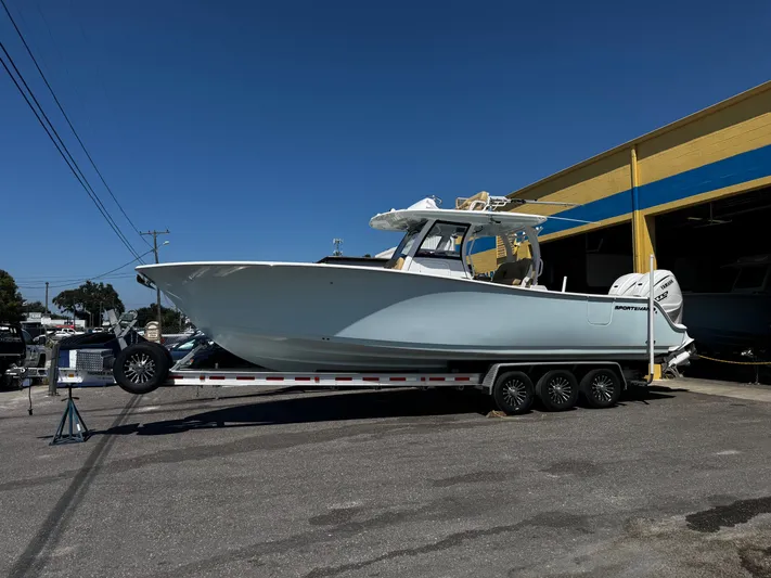  Yacht Photos Pics 2024 Sportsman Open 322 Center Console boat on trailer outside a building.