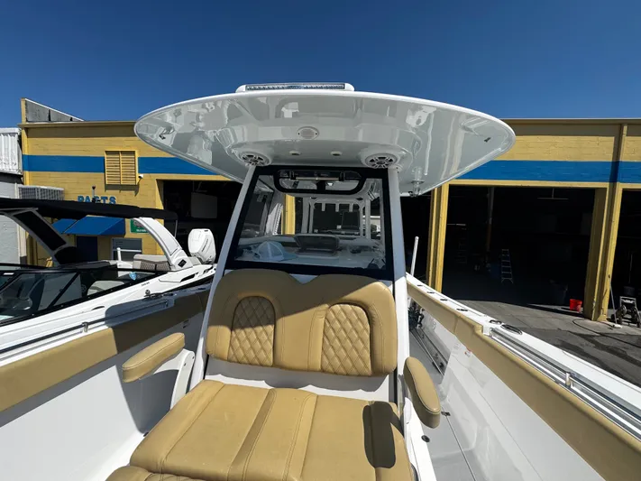  Yacht Photos Pics 2024 Sportsman Open 322 Center Console boat with tan seating and T-top in a marina setting.