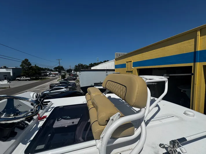  Yacht Photos Pics 2024 Sportsman Open 322 Center Console boat with tan seating, parked near a yellow building.