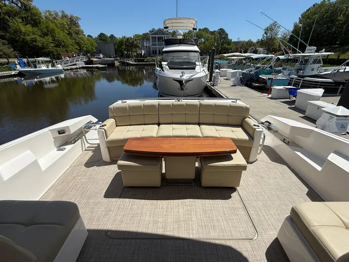 Swift Wing Yacht Photos Pics 2016 Tiara Yachts 50 Coupe with spacious outdoor seating and table, docked at a marina.