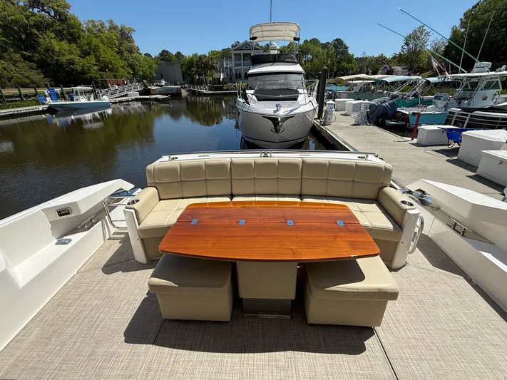 Swift Wing Yacht Photos Pics 2016 Tiara Yachts 50 Coupe with elegant outdoor seating and table, docked at a marina.