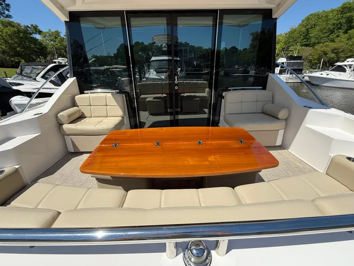Swift Wing Yacht Photos Pics 2016 Tiara Yachts 50 Coupe with elegant outdoor seating and polished wooden table.