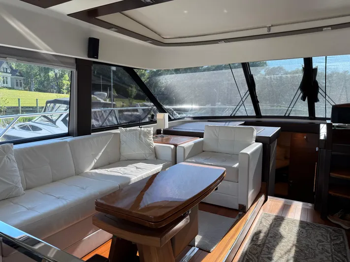 Swift Wing Yacht Photos Pics Luxurious interior of 2016 Tiara Yachts 50 Coupe with white seating and wooden table.