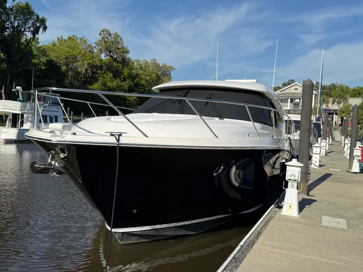 Swift Wing Yacht Photos Pics 2016 Tiara Yachts 50 Coupe docked, sleek design, black hull, sunny day.
