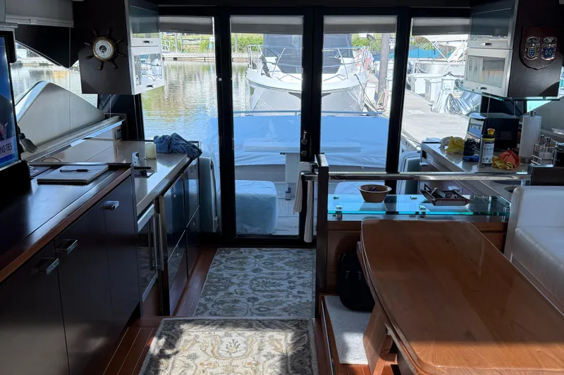 Swift Wing Yacht Photos Pics Interior of 2016 Tiara Yachts 50 Coupe, featuring modern kitchen and dining area with marina view.