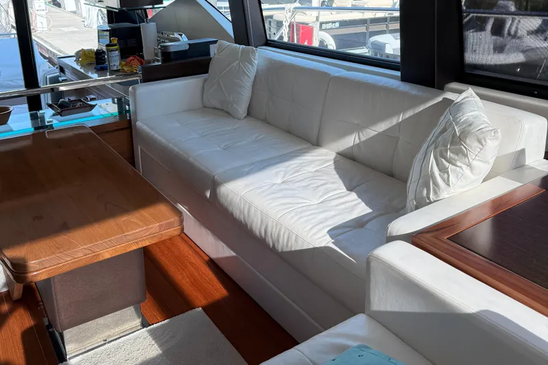 Swift Wing Yacht Photos Pics Luxurious interior of 2016 Tiara Yachts 50 Coupe with white sofa and wooden table.